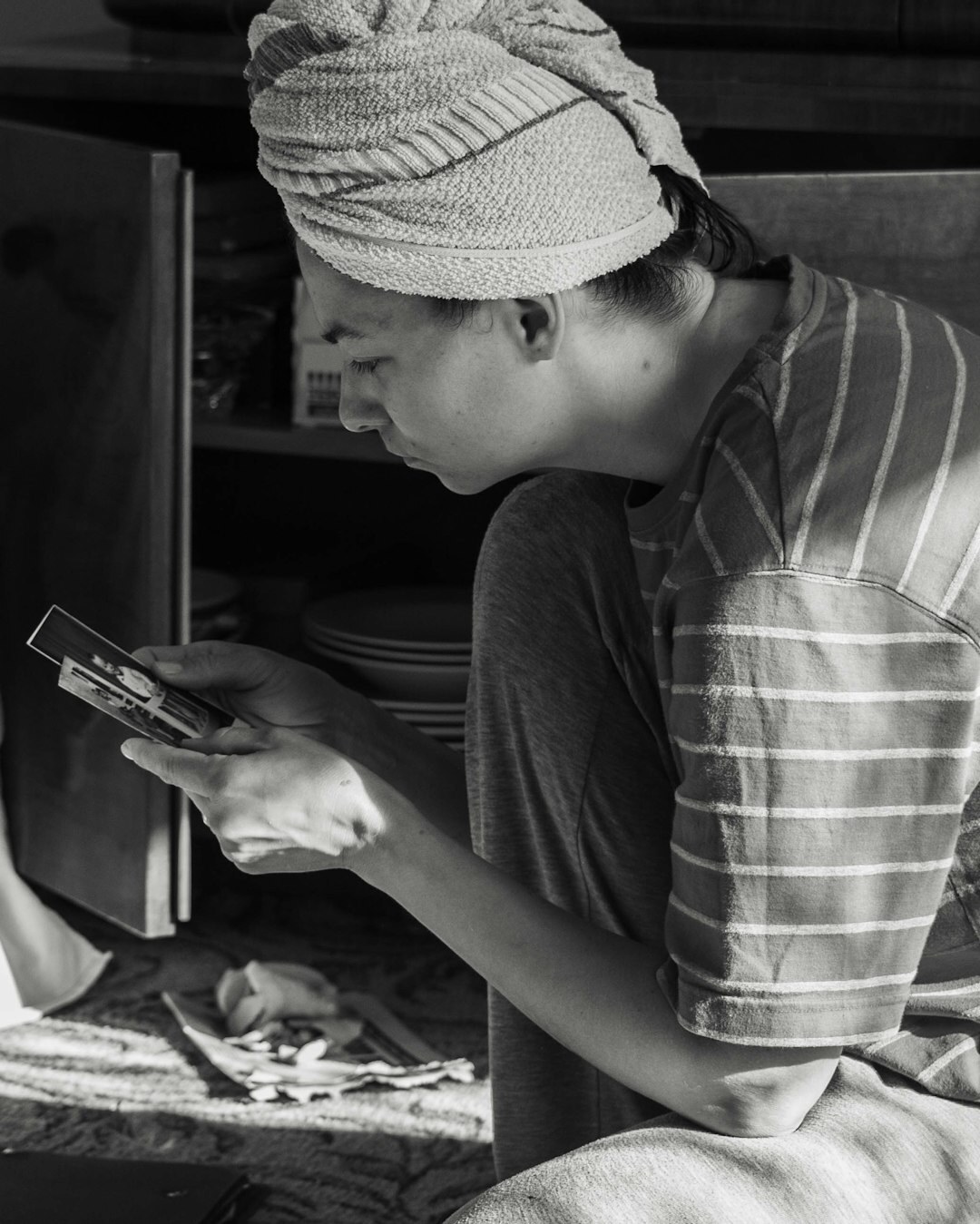 Czech woman smiling while reading a recipe on her phone in the kitchen