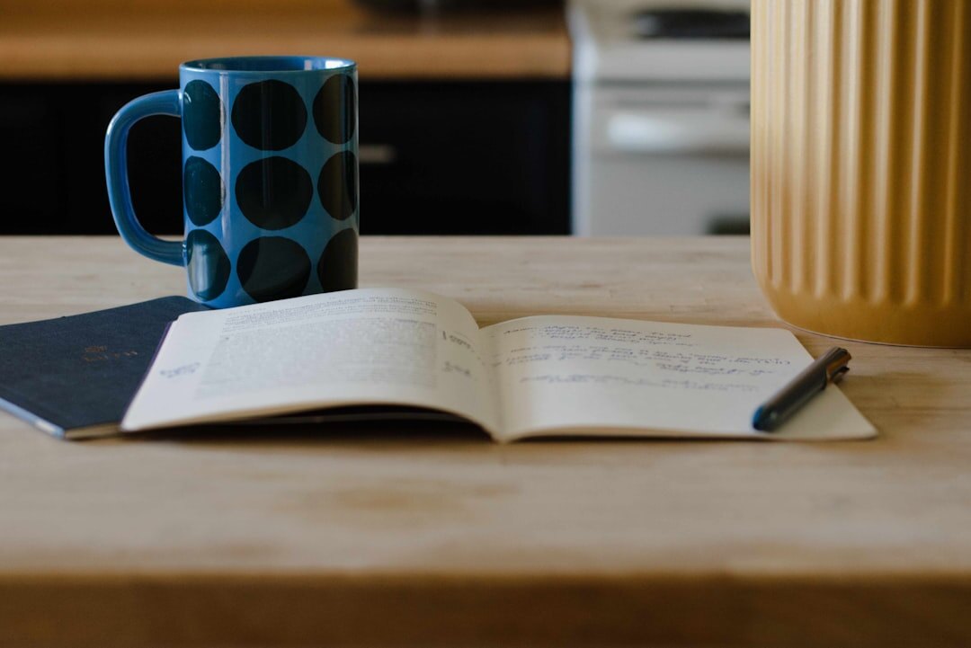 Notebook with handwritten recipes and a cup of tea on a table