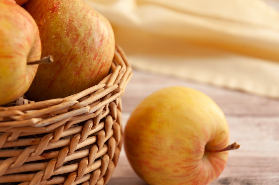 Basket of autumn vegetables, mushrooms and apples on a wooden table